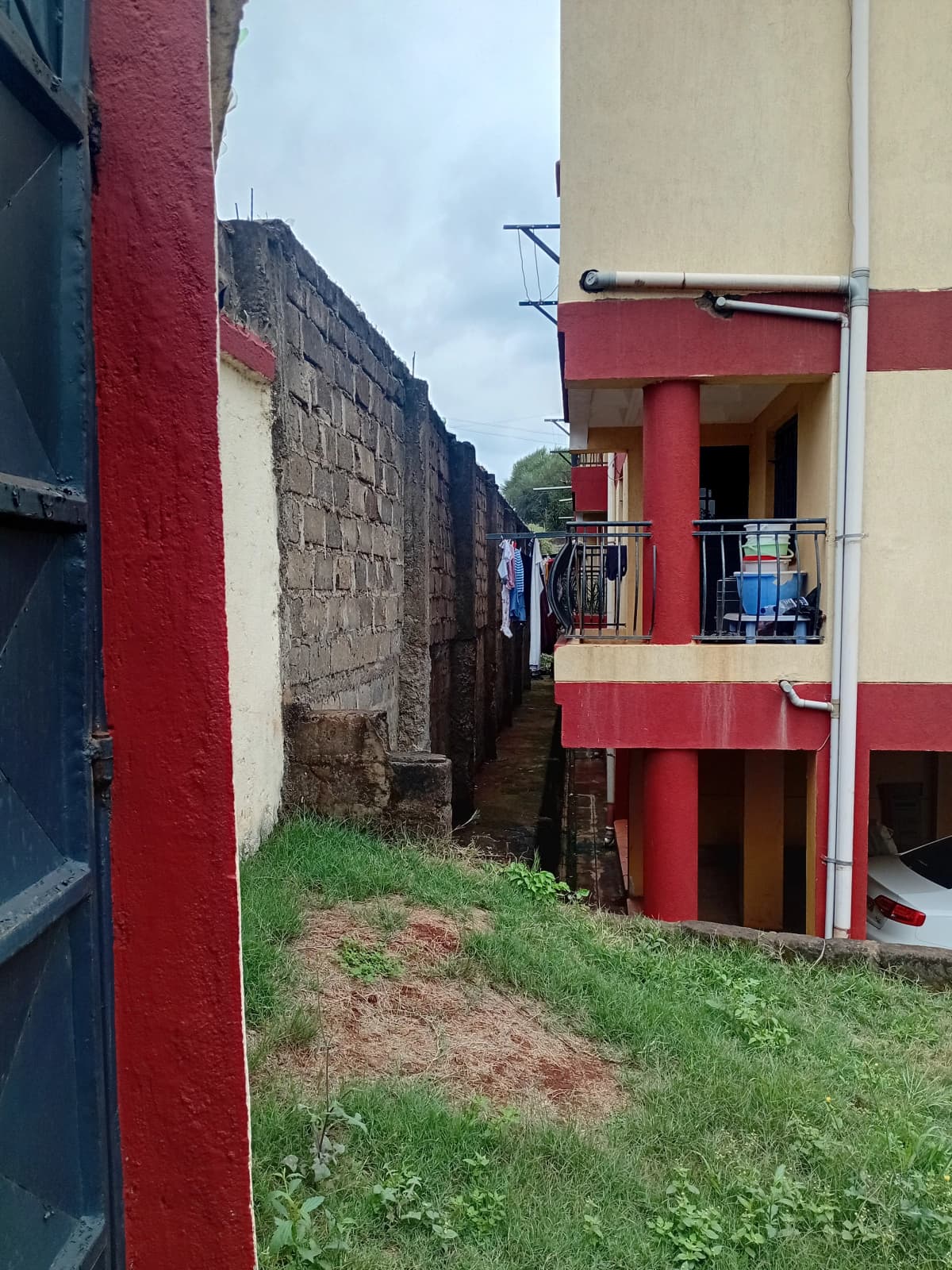 Red and cream residential building with side compound view