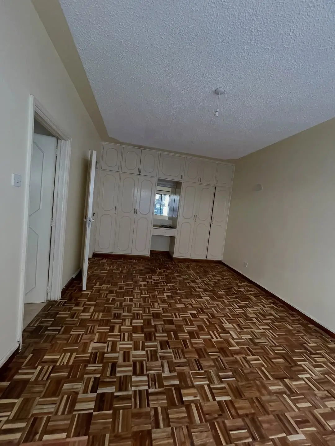 Spacious bedroom with built-in wardrobes and parquet flooring