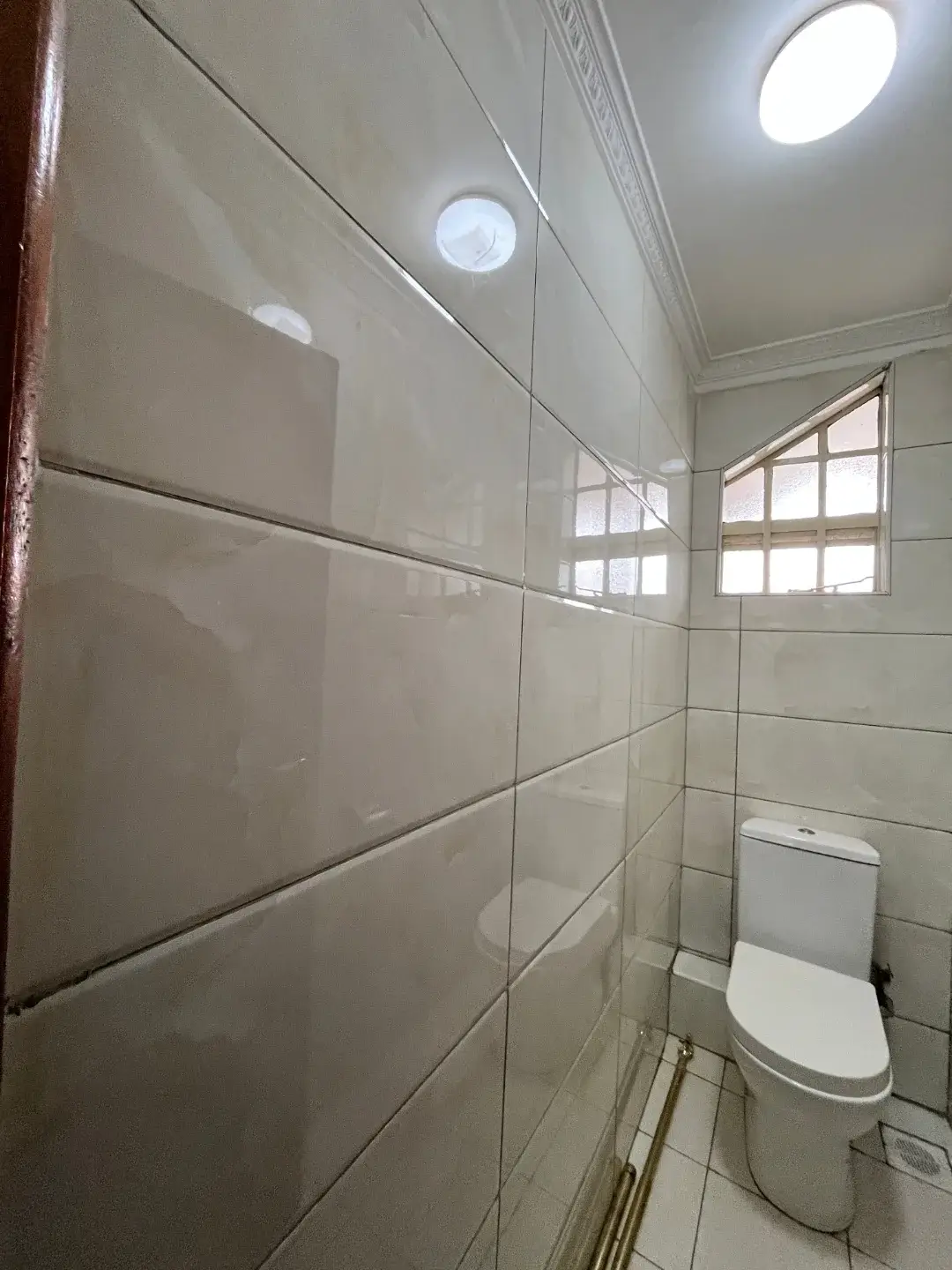 Modern bathroom with large-format tiles and toilet fixture