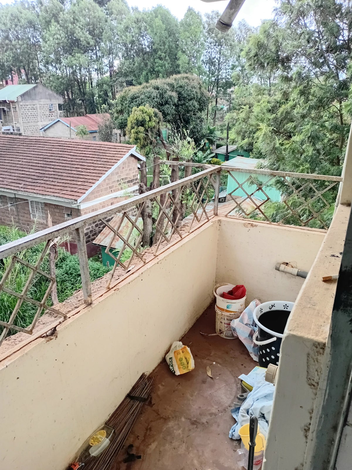 Balcony with forest views, metal railings, storage items