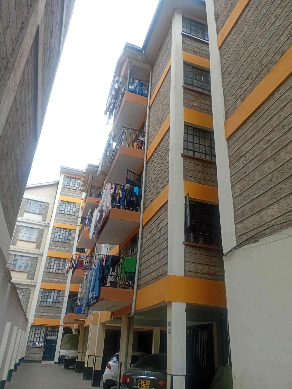 Multi-story residential building facade with orange and grey bands