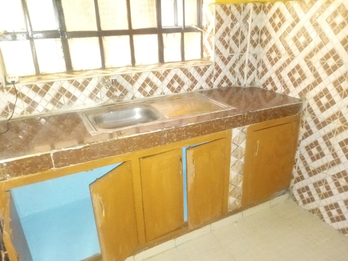 Kitchen with yellow cabinetry and granite countertop sink