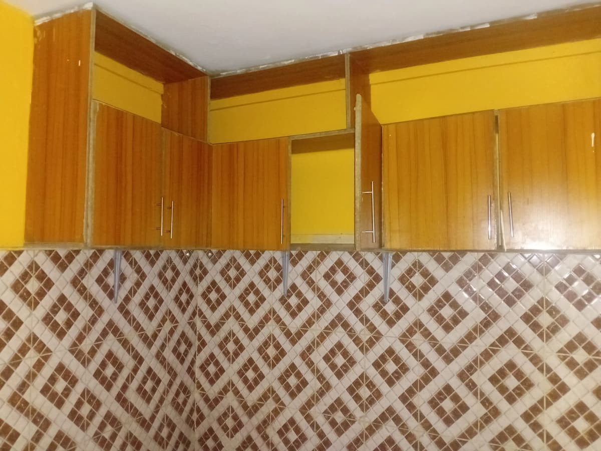 Bright yellow kitchen with wooden cabinets and geometric tile backsplash