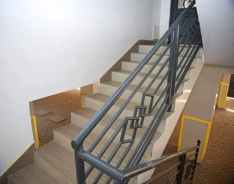 Indoor staircase with metal handrail and safety markers