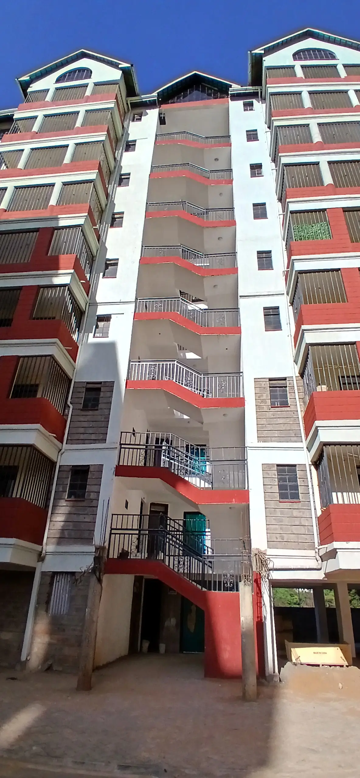 Multi-story residential building facade with red balconies