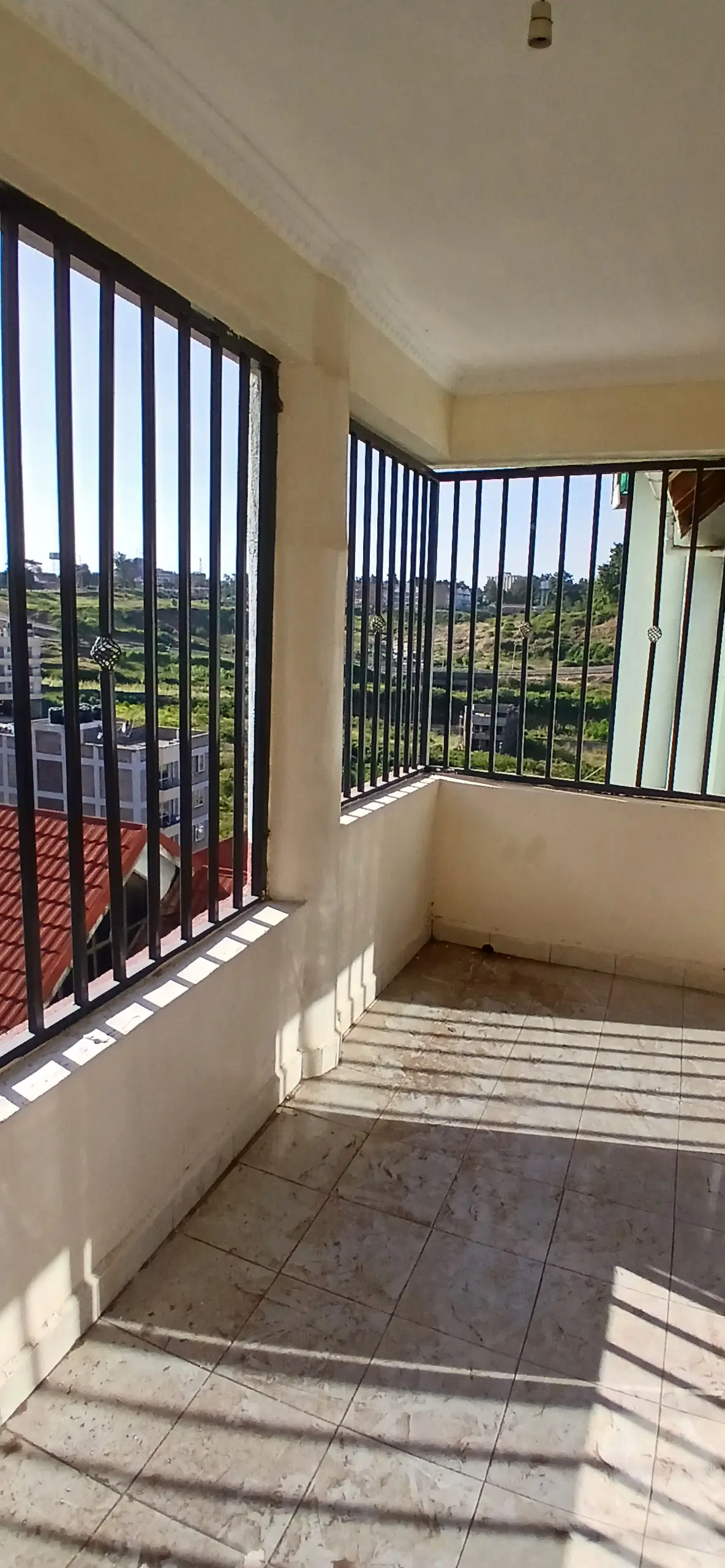 Bright balcony with black railings and city views