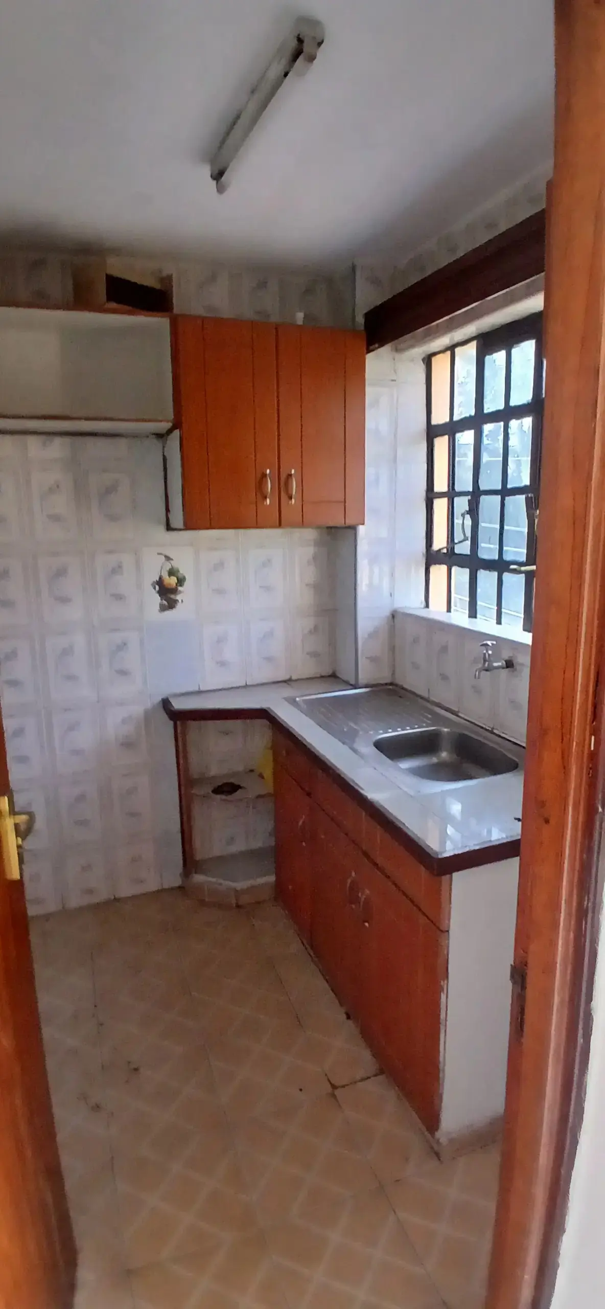 Compact kitchen with red cabinetry and stainless steel sink