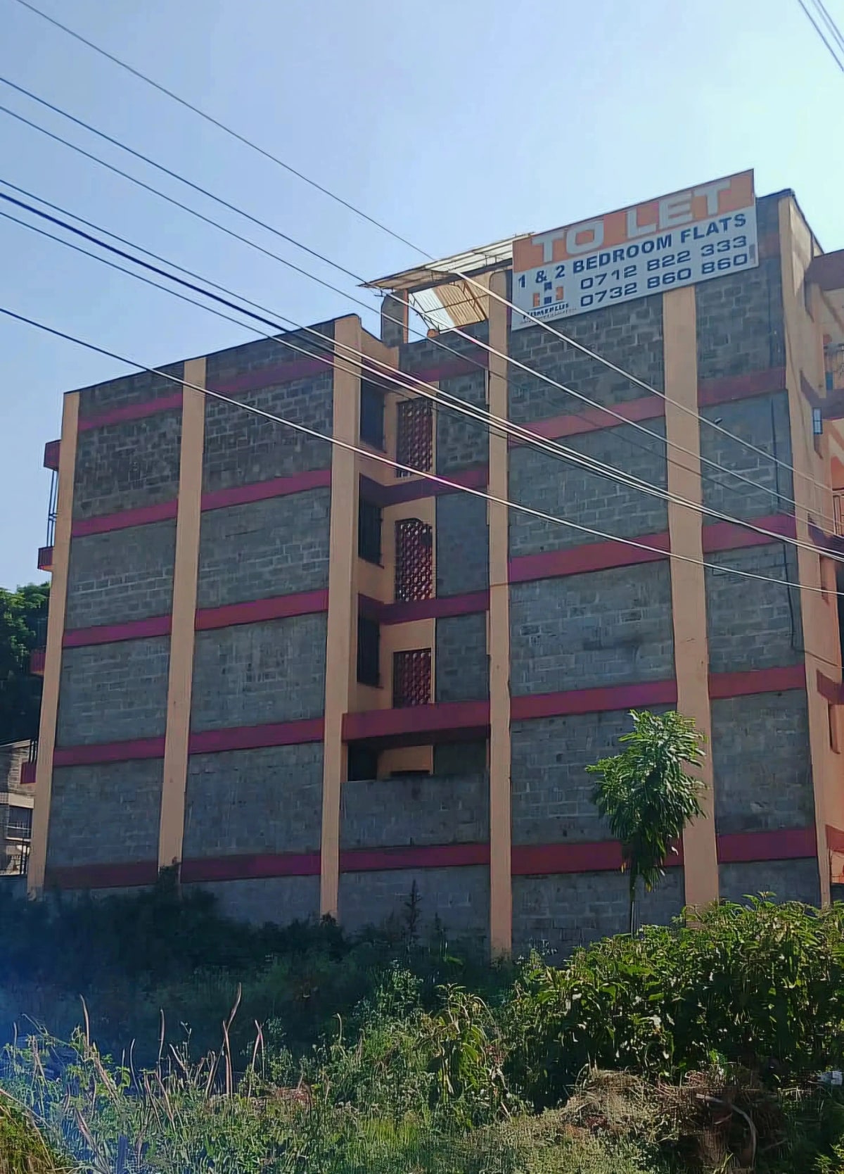 Multi-story residential building facade with red and cream stripes