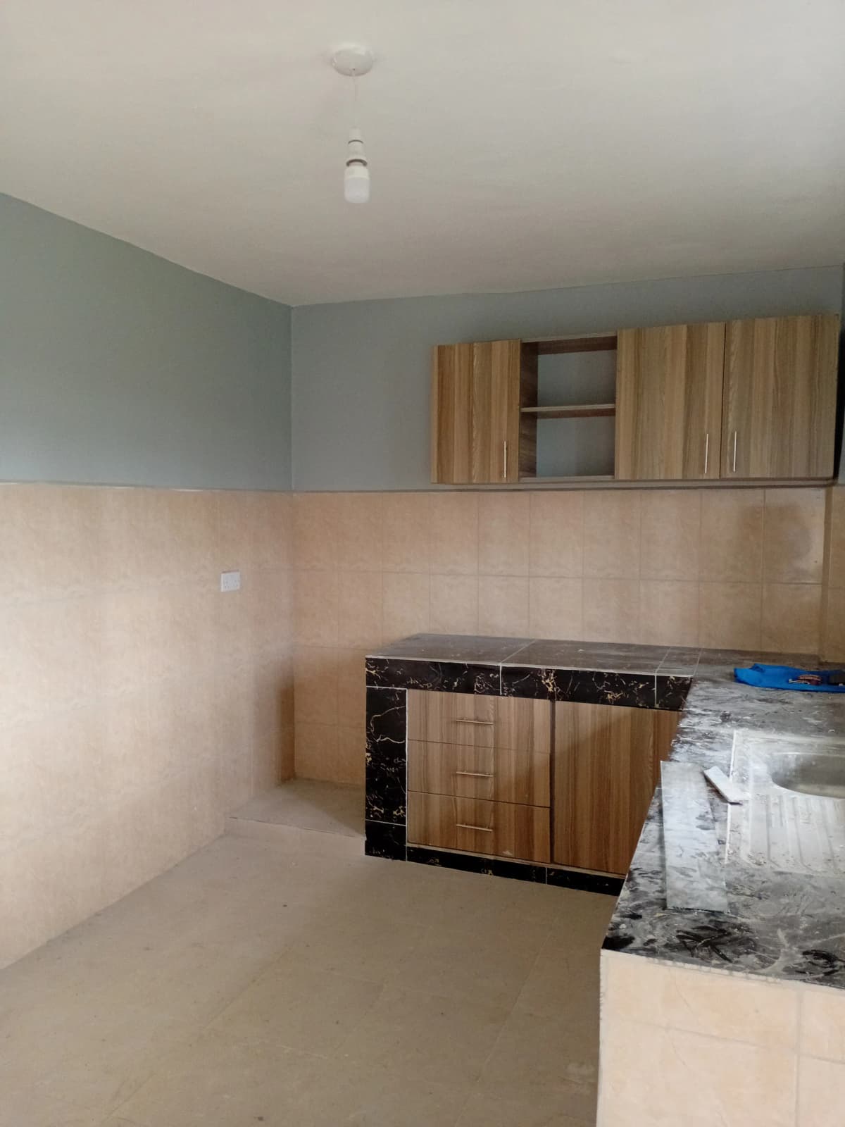 Unfurnished kitchen with wooden cabinetry and black countertop