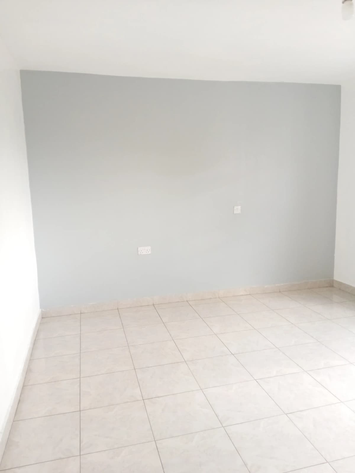 Empty room with plain walls and tiled flooring
