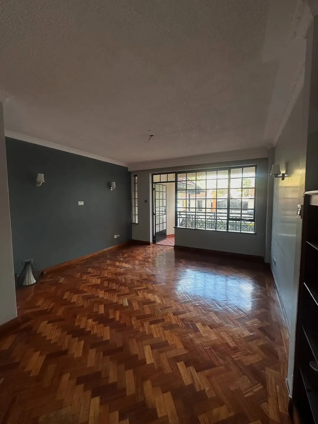 Spacious living room with herringbone floor and city views