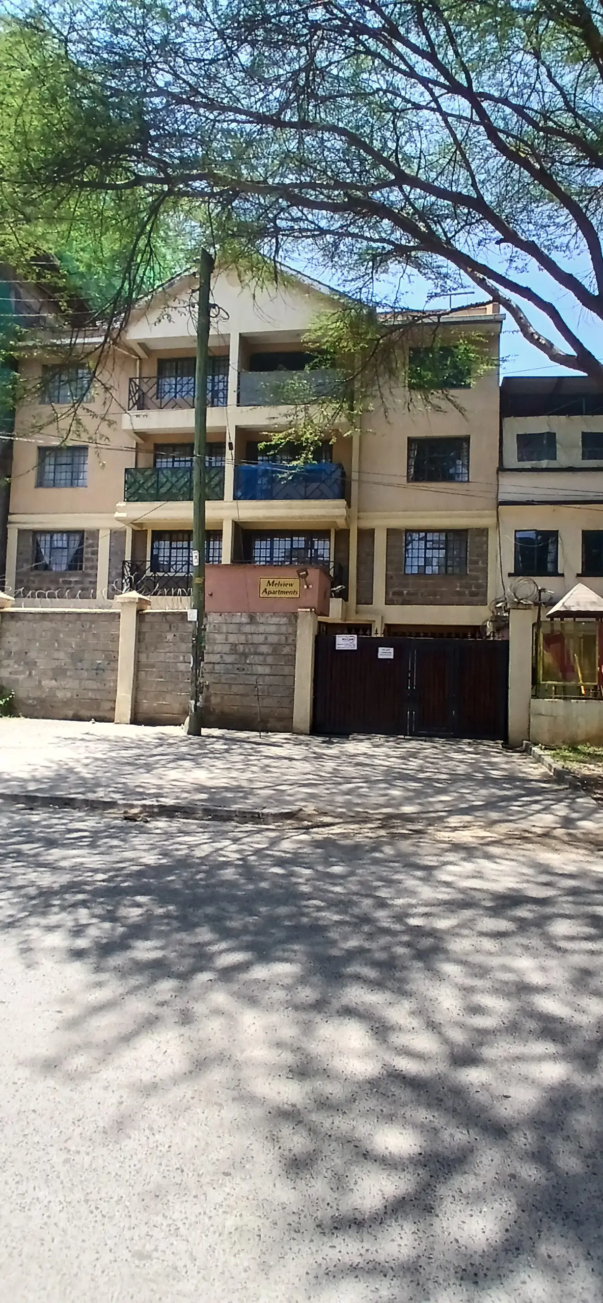 Multi-story residential building facade with gated entrance