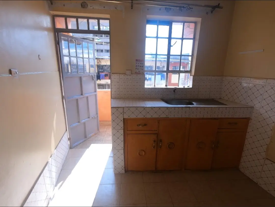 Kitchen with wooden cabinet, sink, and bright natural light