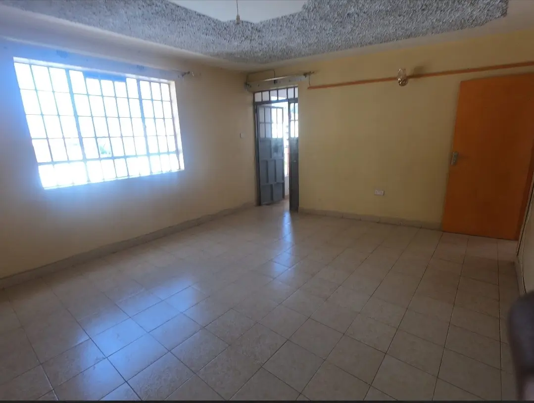 Spacious empty living room with large window and tiled flooring