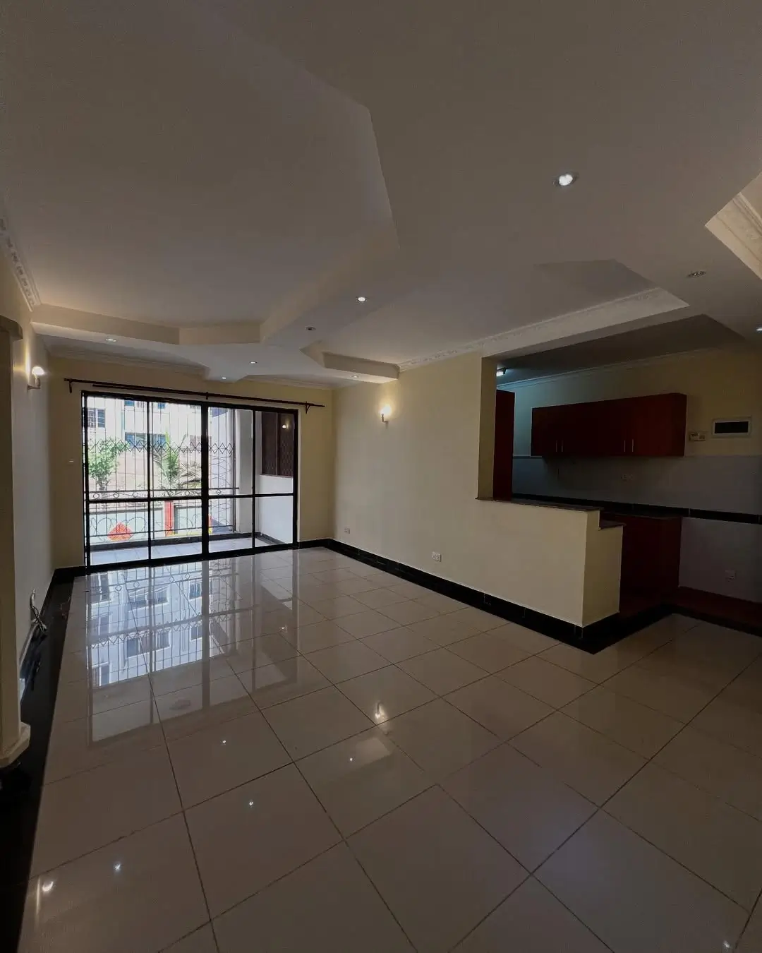 Spacious open-plan living area with polished floors and glass doors