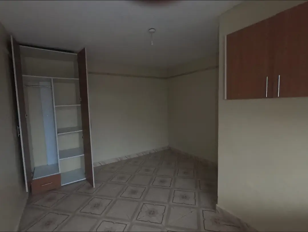 Compact kitchen with red cabinetry and tiled flooring