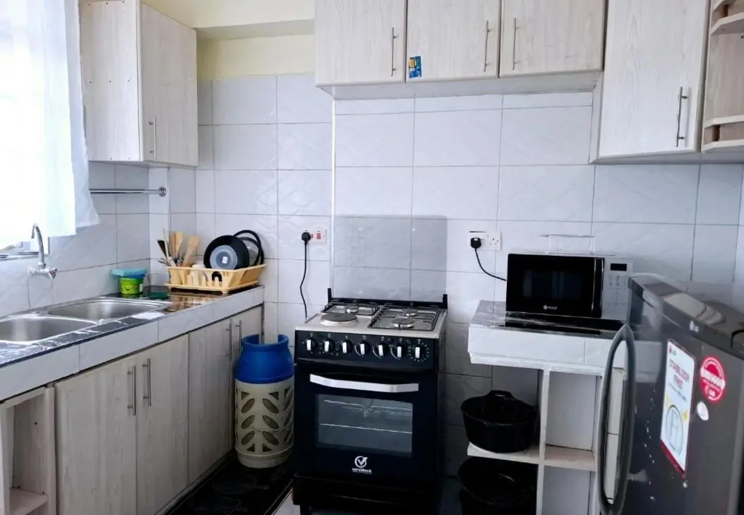 Compact kitchen with black range cooker and white tile backsplash