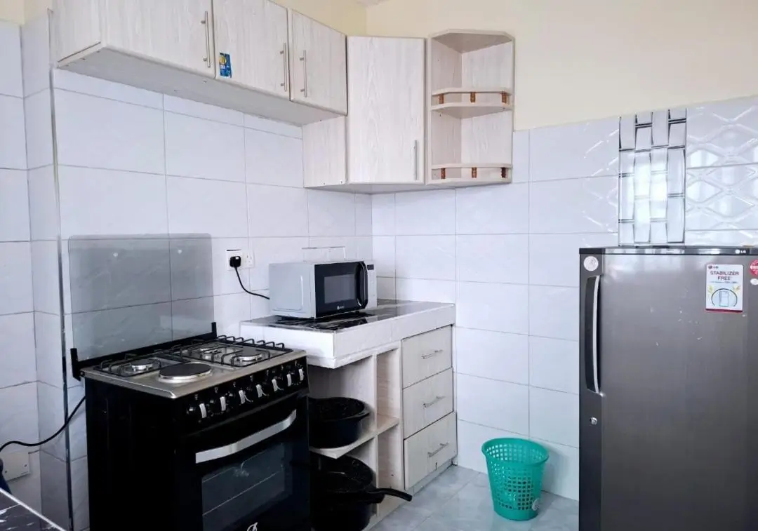 Compact kitchen with black gas cooker and dark refrigerator