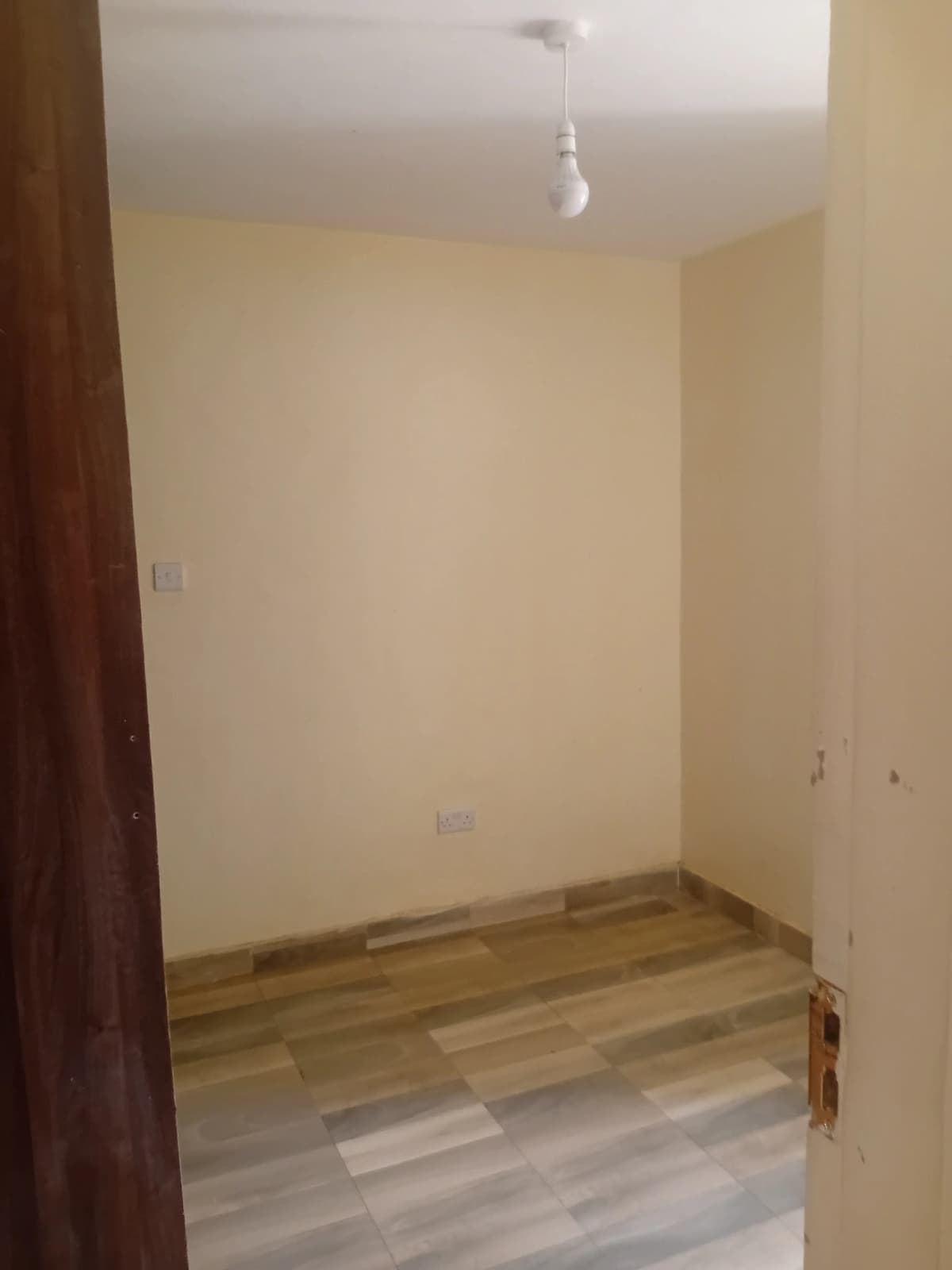 Empty bedroom with wooden flooring and cream walls