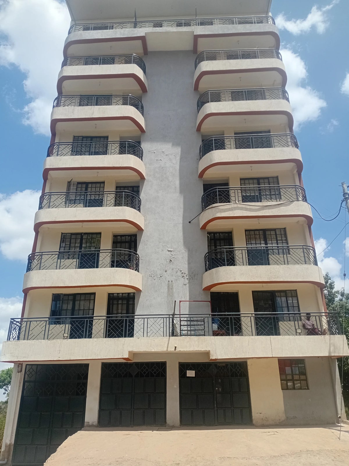 Multi-story residential building facade with balconies and parking bays