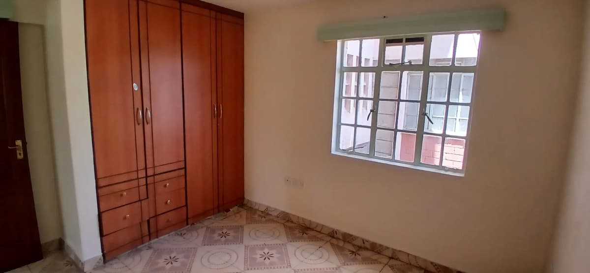 Empty bedroom with wooden wardrobe and window
