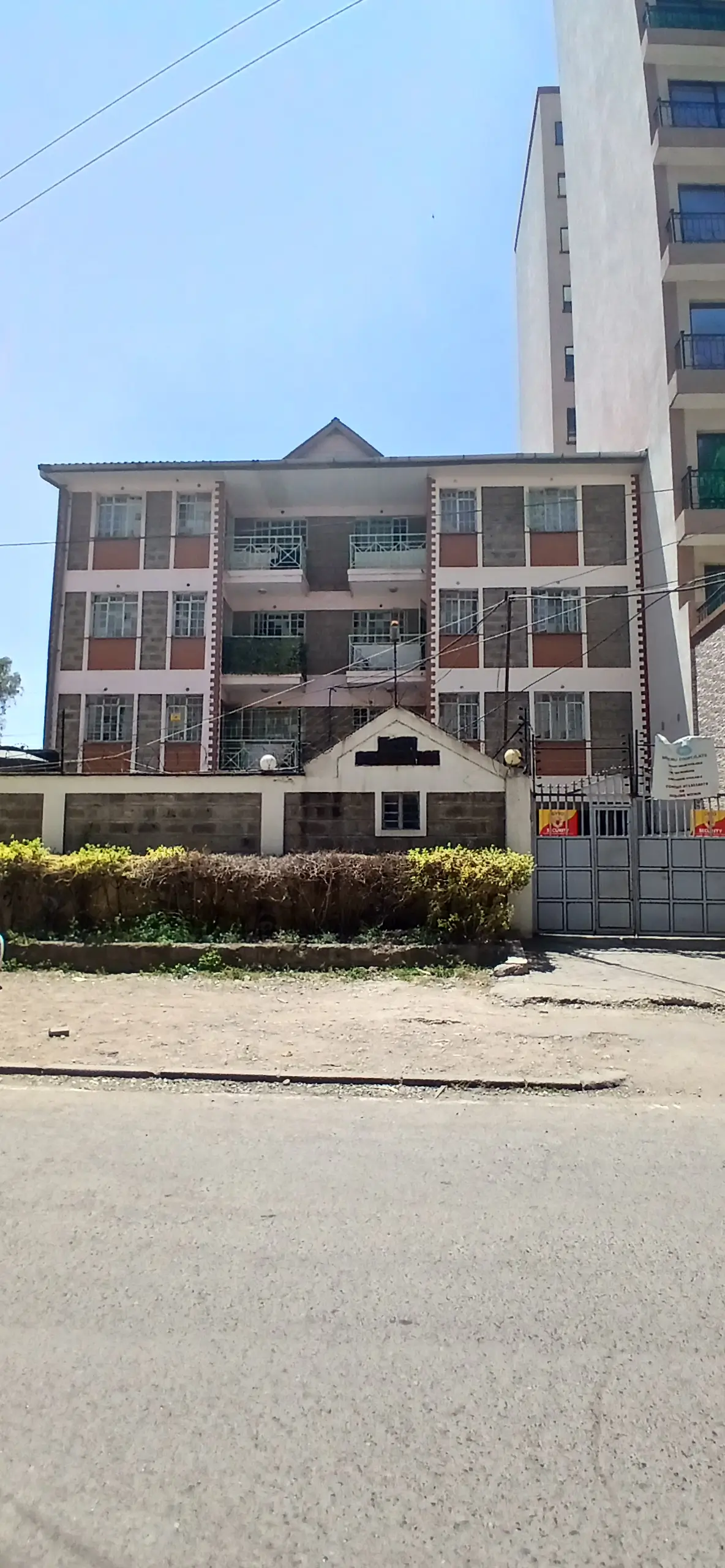 Multi-story residential building facade with gated entrance