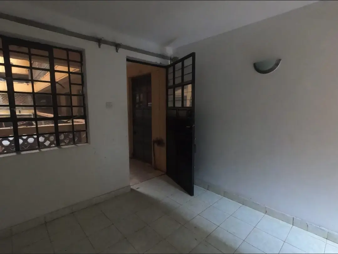 Bright corridor with barred window and open doorway