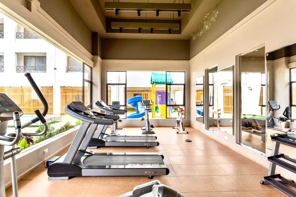 Modern gym with treadmills, exercise bikes, and floor-to-ceiling windows