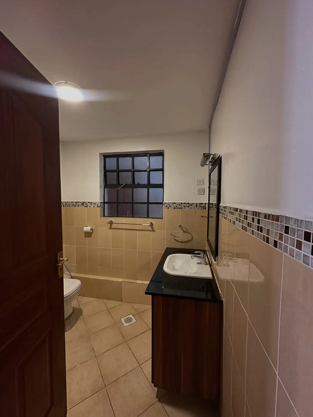 Bathroom with black sink vanity and tiled walls