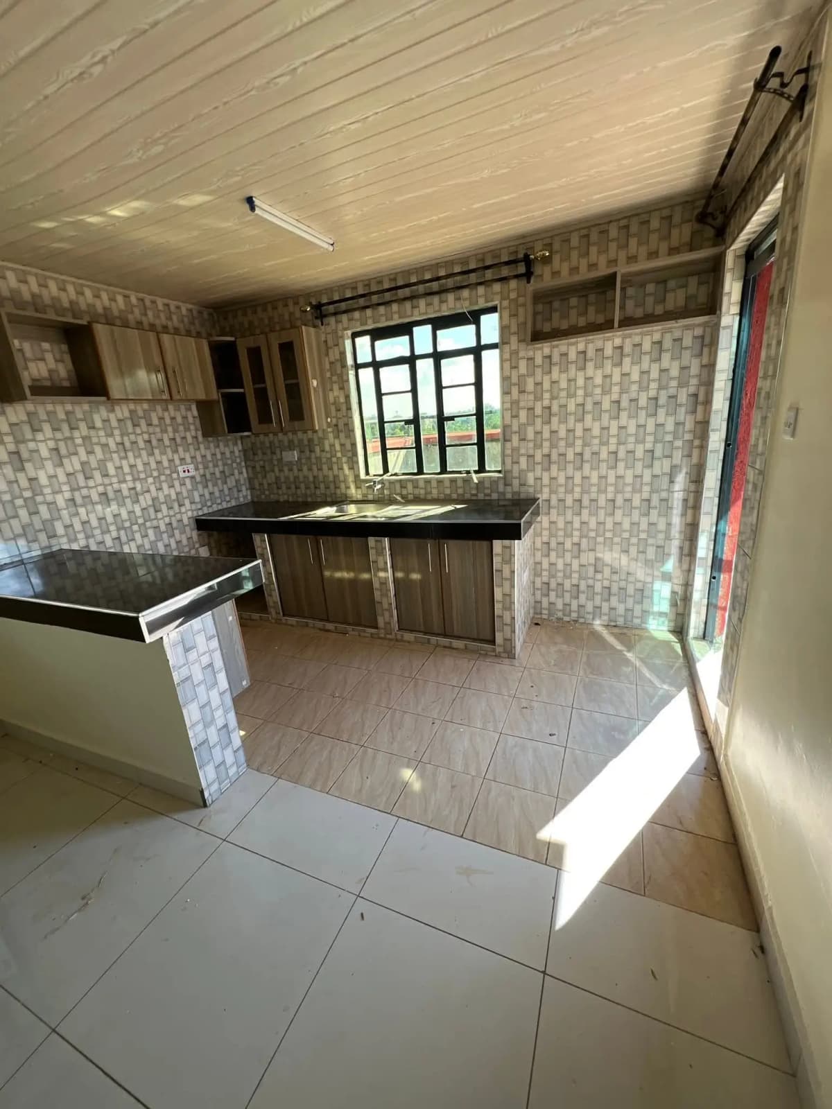 Spacious kitchen with dark cabinetry and tiled backsplash