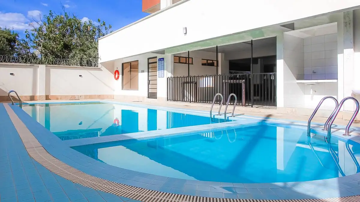Large indoor swimming pool with ladder and clean blue water