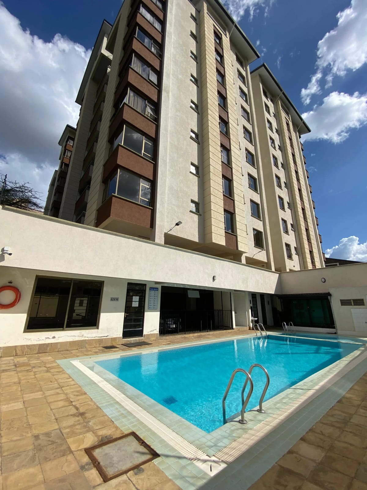 Residential building with turquoise swimming pool and tiled deck