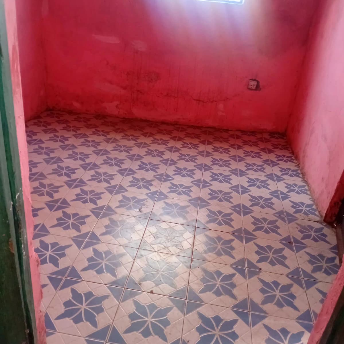 Empty room with patterned tile floor and pink walls