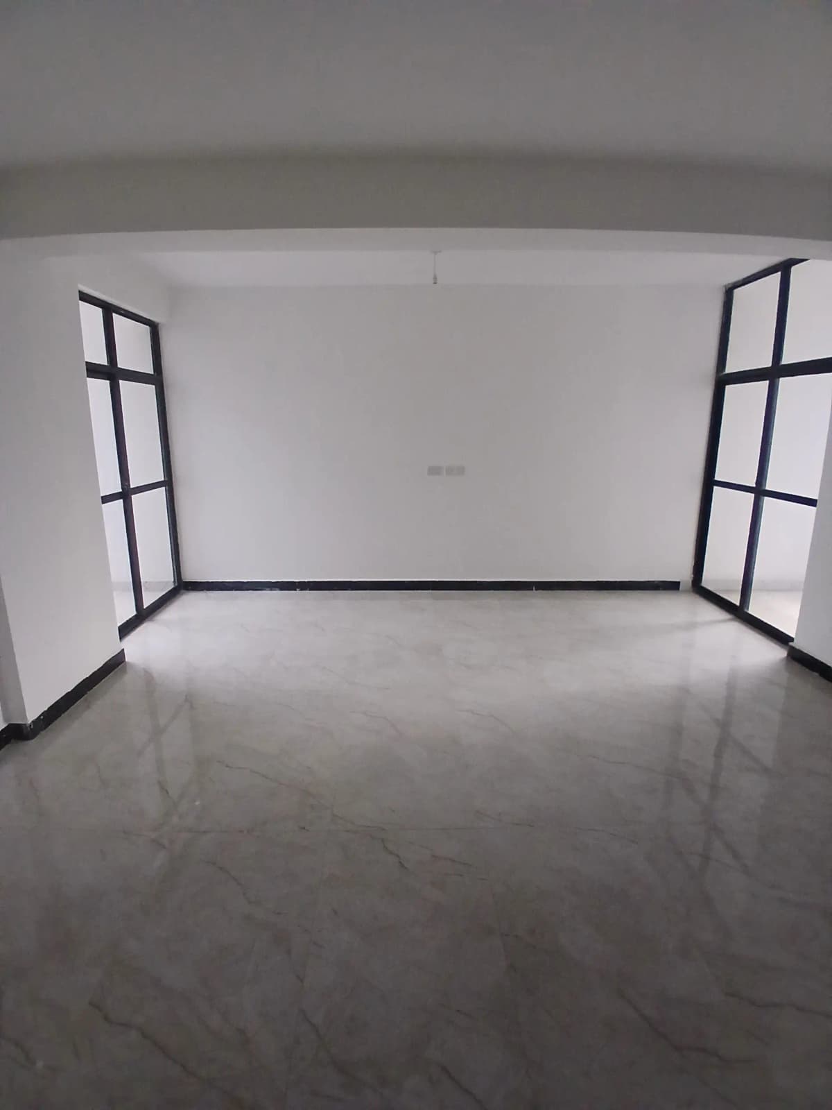 Empty living space with large windows and polished concrete floor