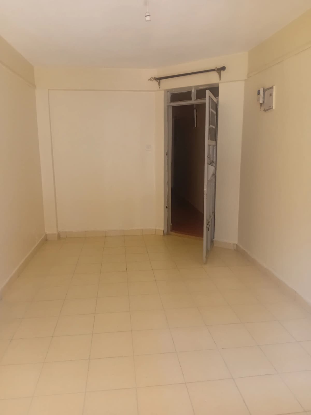 Empty bedroom with tiled flooring and sliding door access