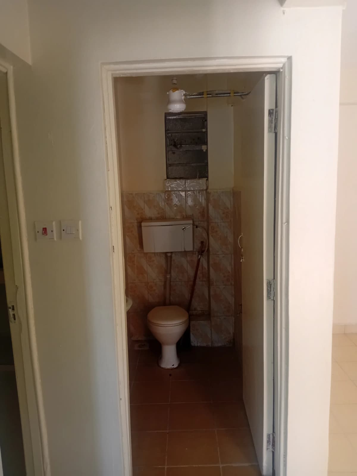 Compact bathroom with toilet and wall-mounted cistern