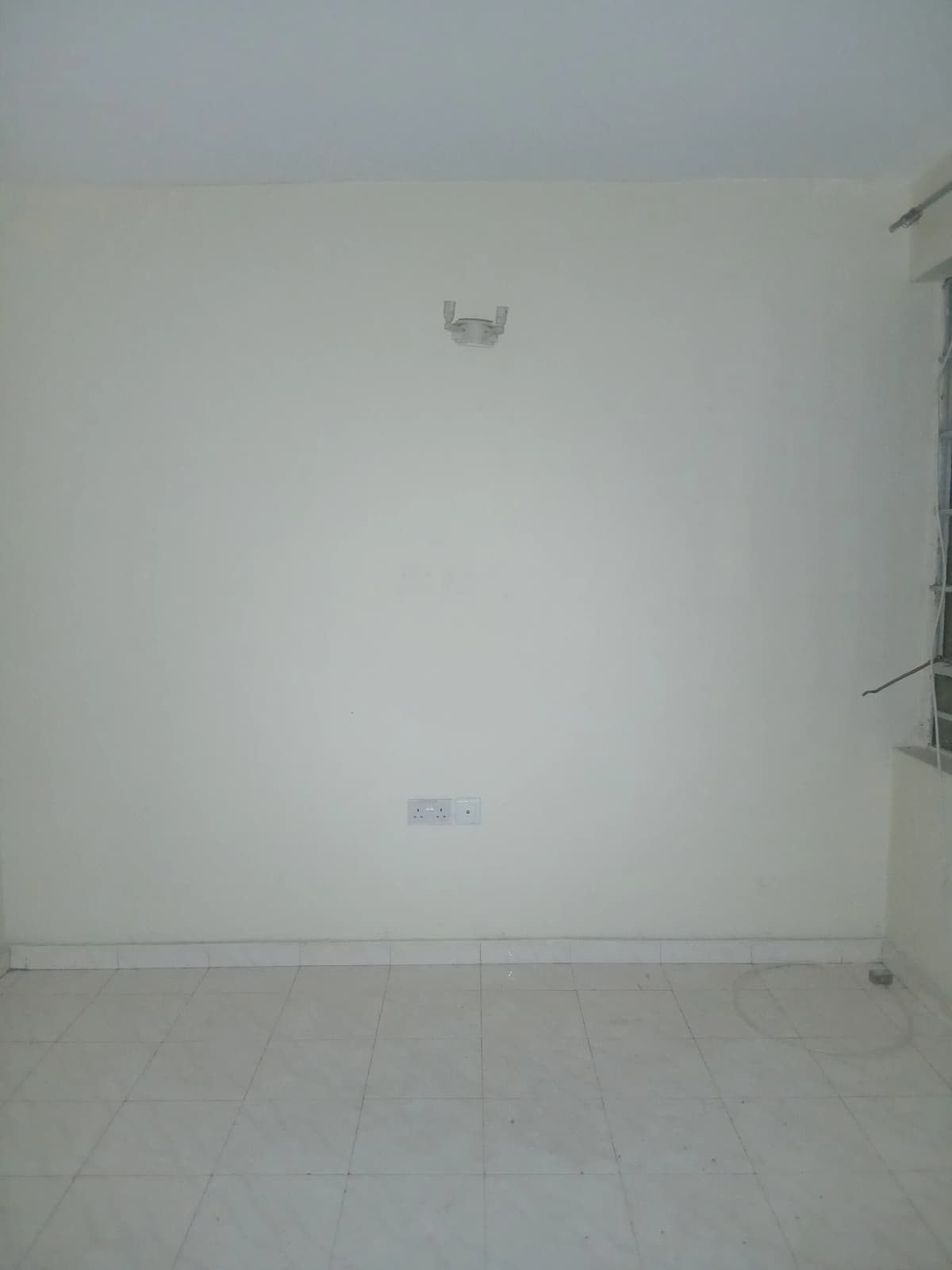 Empty white room with minimal fixtures and polished floor