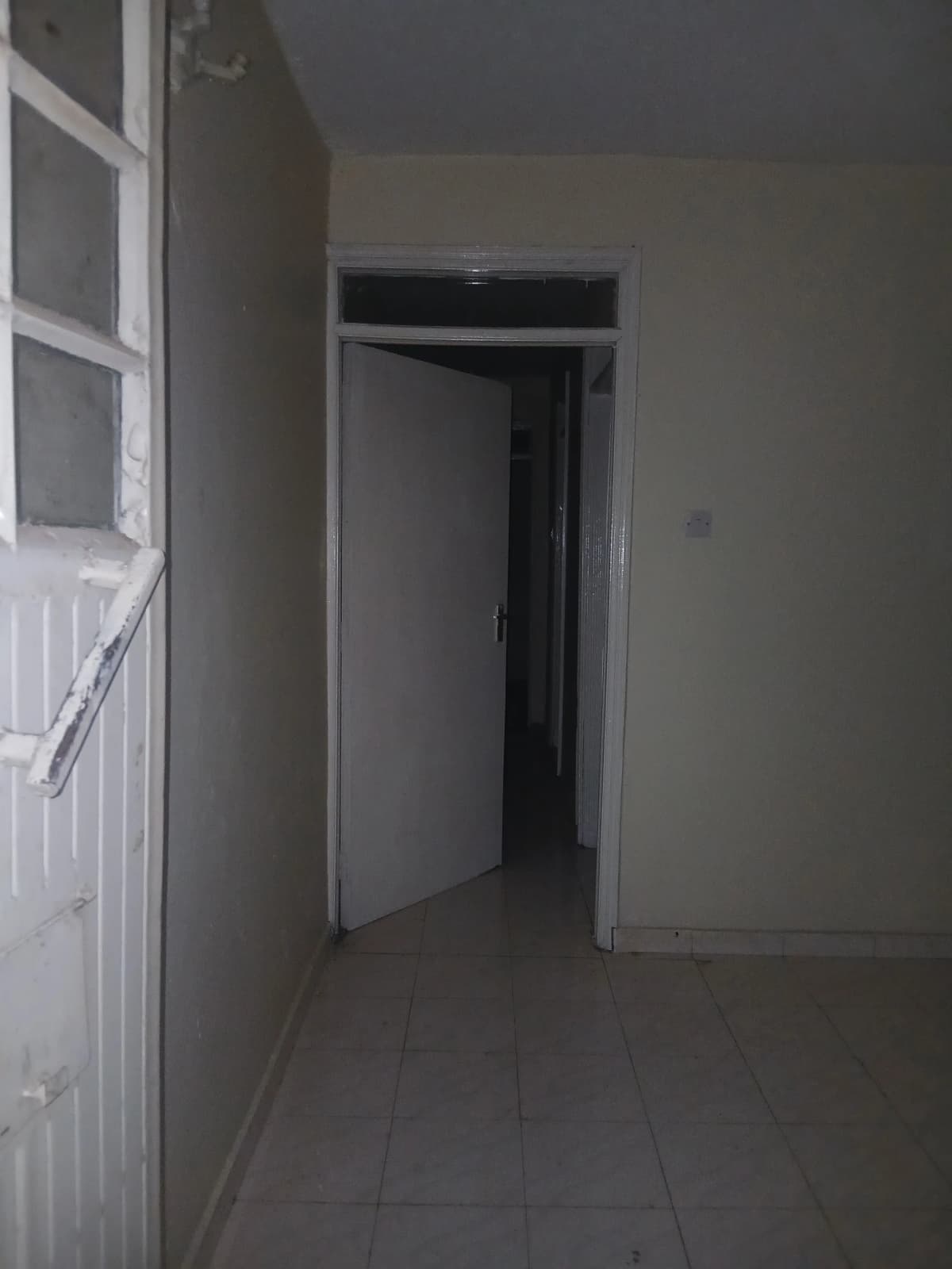 Empty hallway with white door and neutral walls