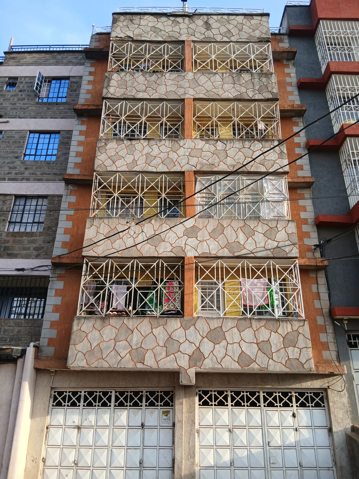Multi-story residential building facade with geometric window grilles