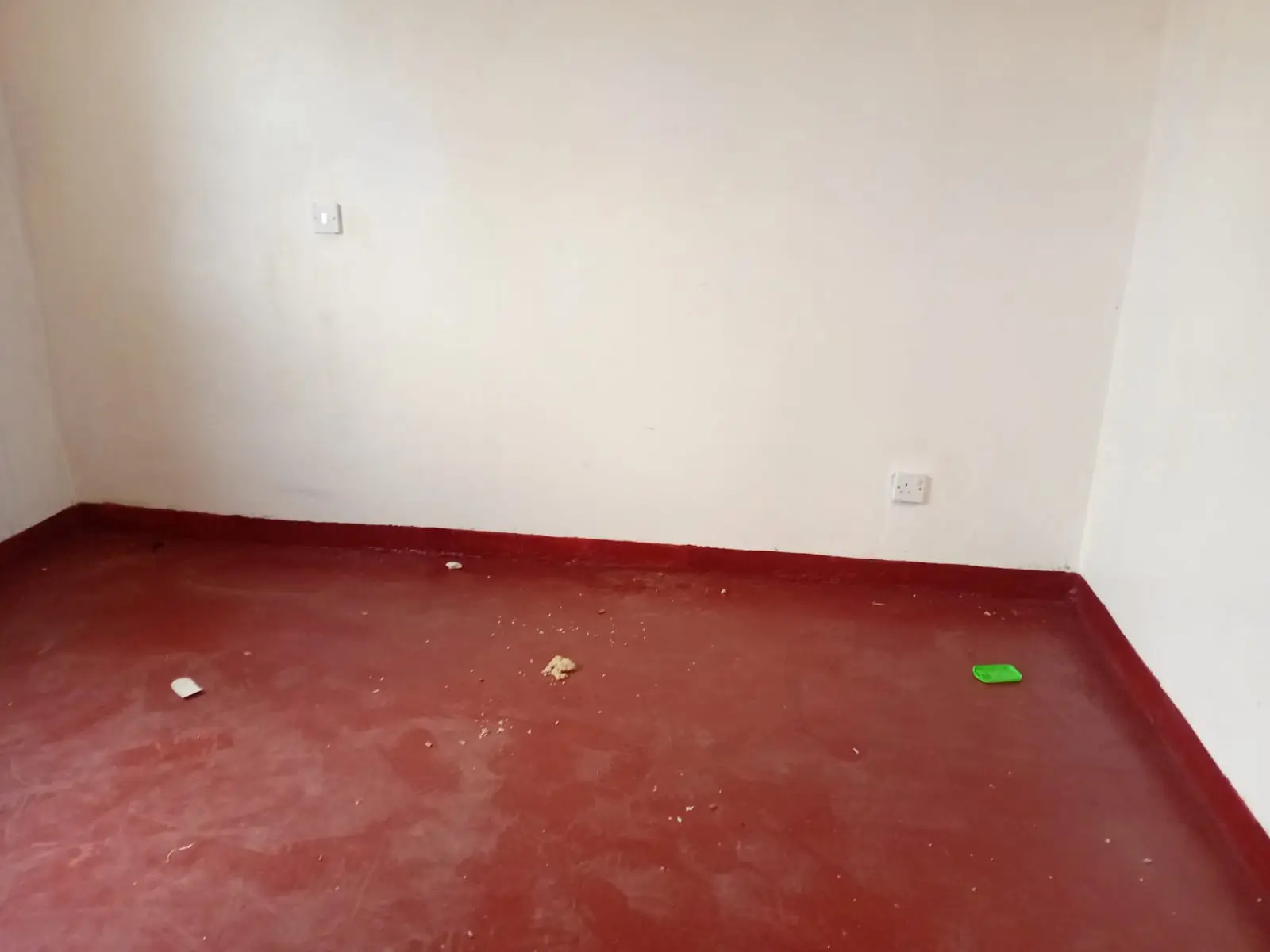 Empty room with red concrete floor, minimal fixtures