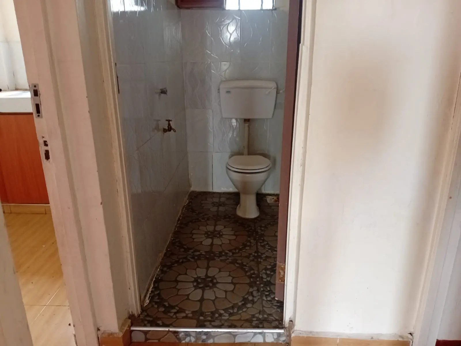 Compact bathroom with toilet, sink, and shower cubicle