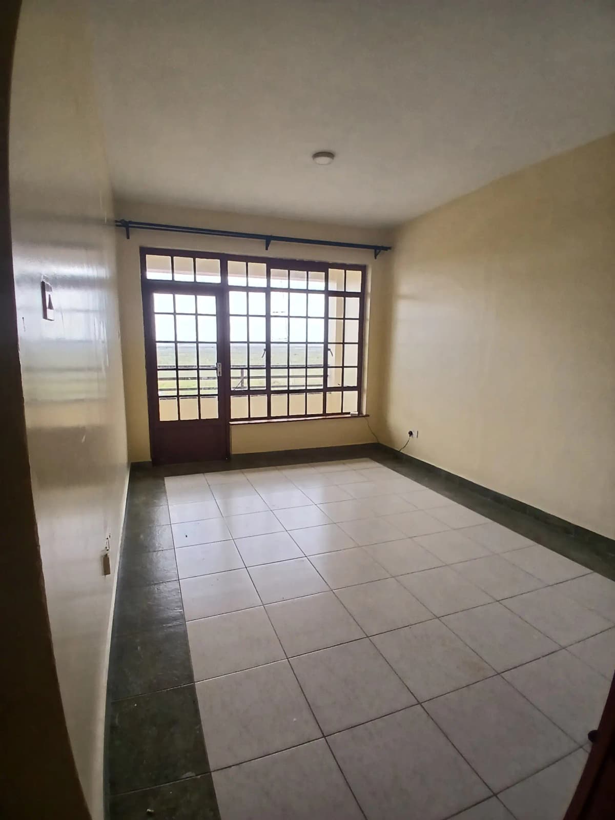 Bright living room with tile flooring and large barred windows