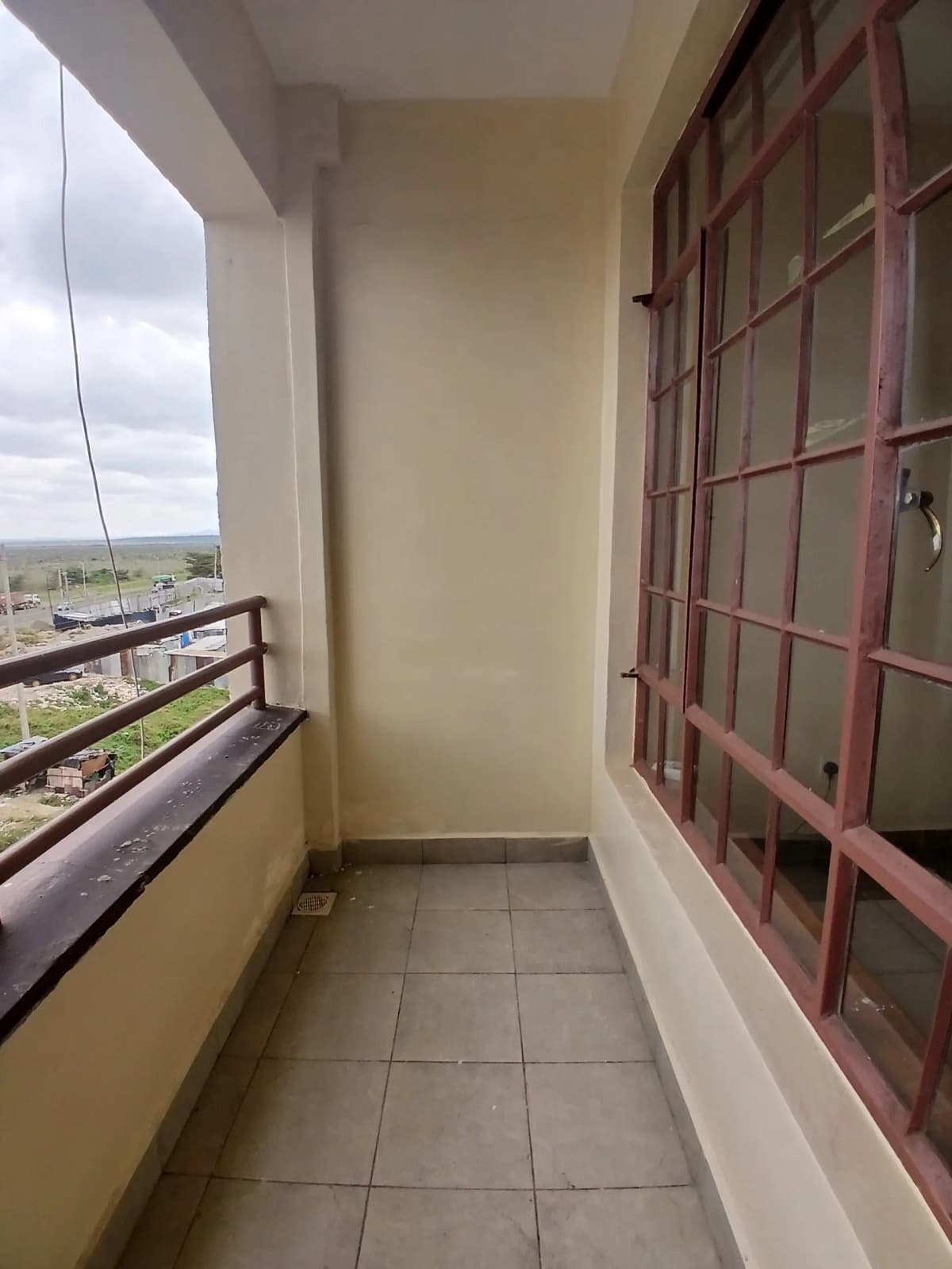 Narrow balcony with city and landscape views, red railings