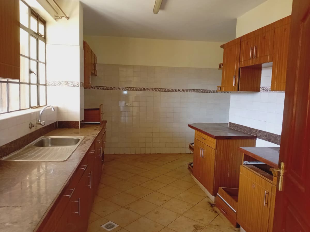 Spacious kitchen with wooden cabinets and long countertop