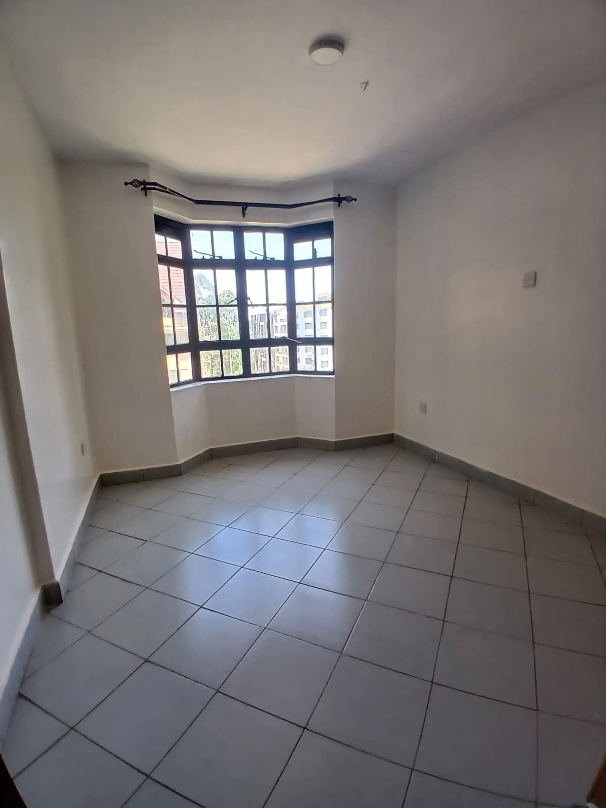 Curved balcony with large windows and tiled flooring