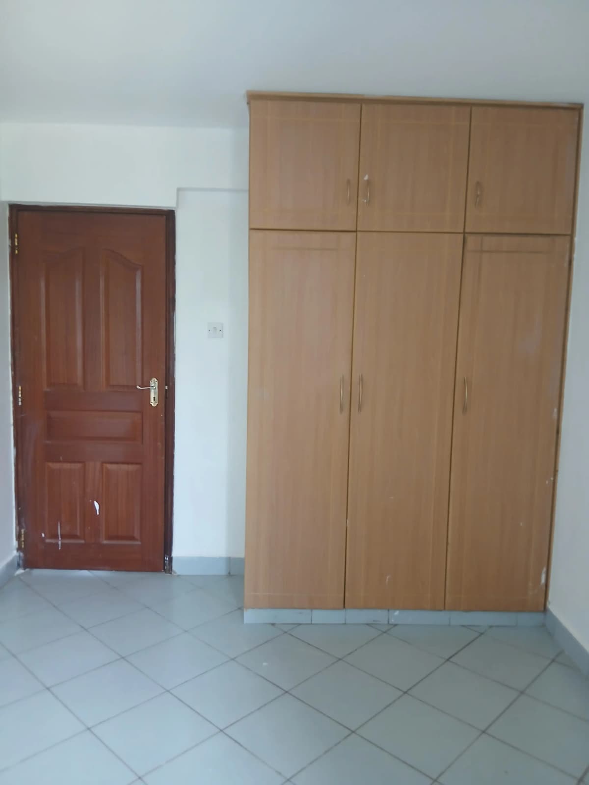 Bedroom with large built-in wooden wardrobe and entrance door