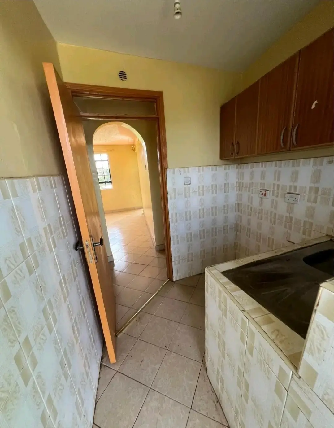 Galley kitchen with tile backsplash and brown cabinetry