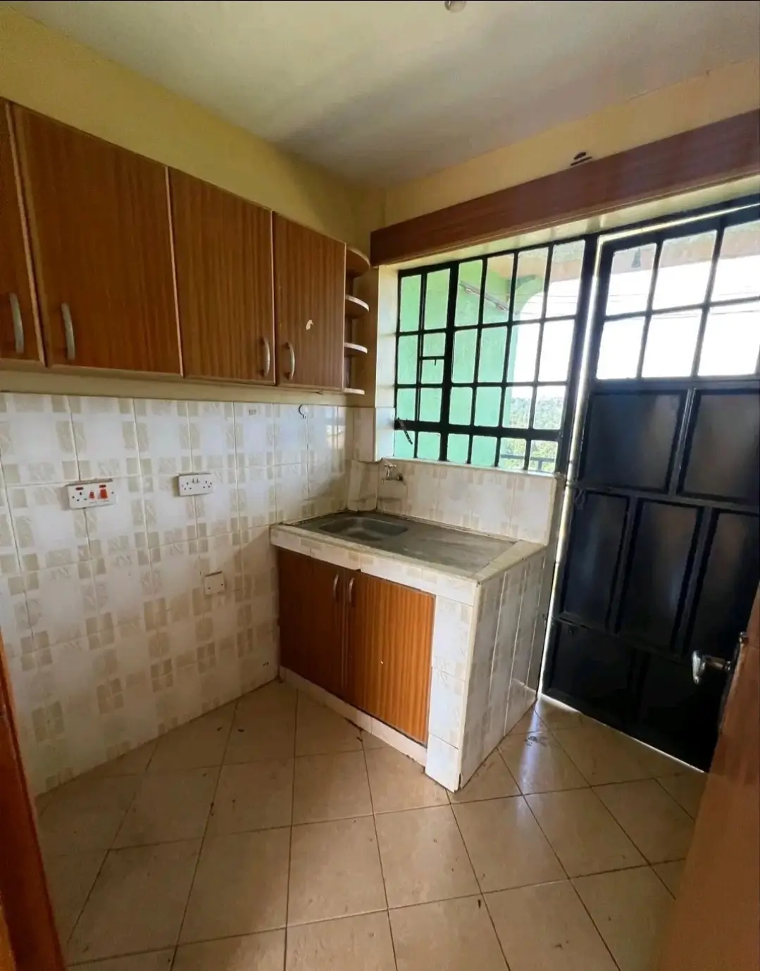 Compact kitchen with wooden cabinets and basic countertop