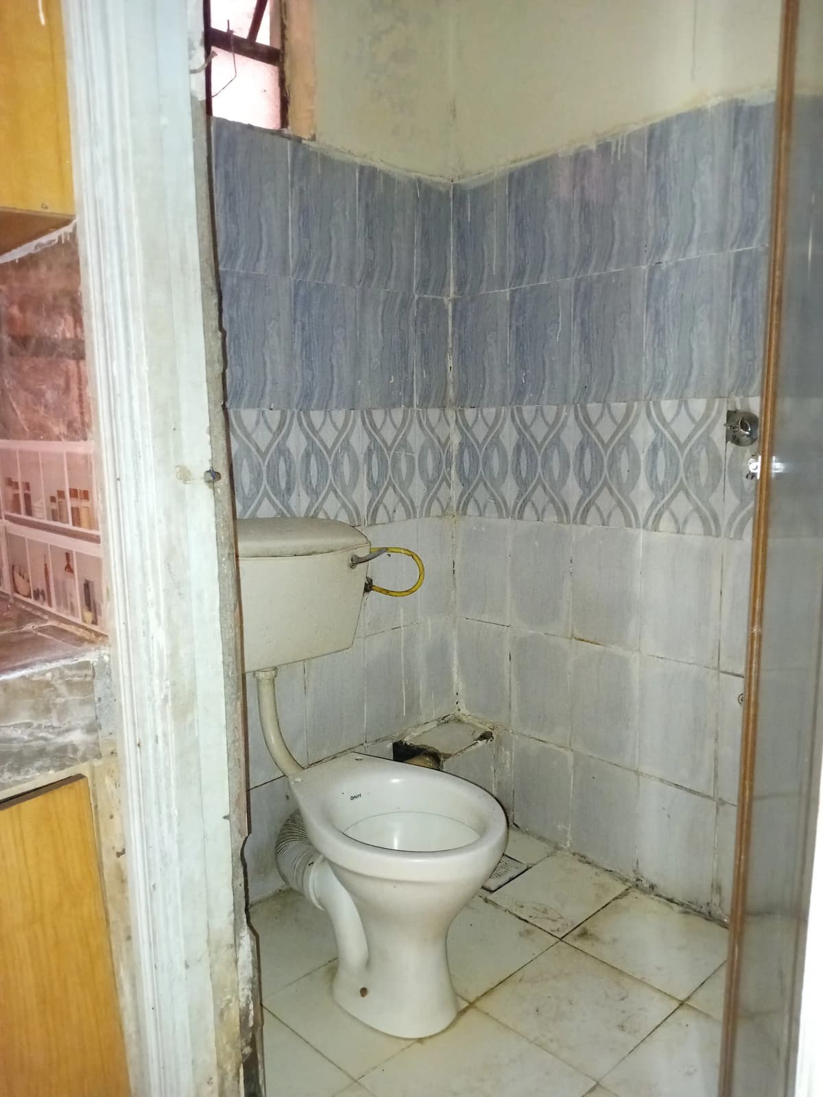 Basic bathroom with toilet, tiled walls, shower curtain rod