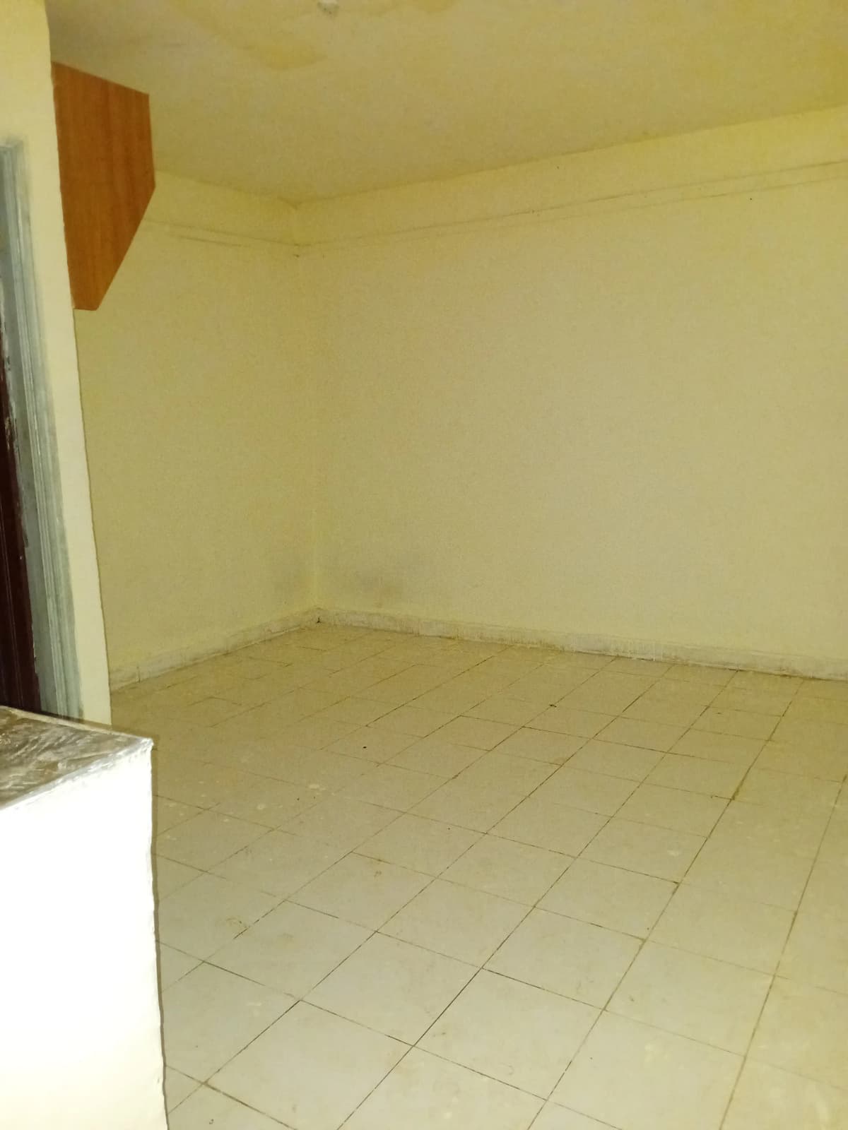 Open kitchen with cream tiling and partial counter visible